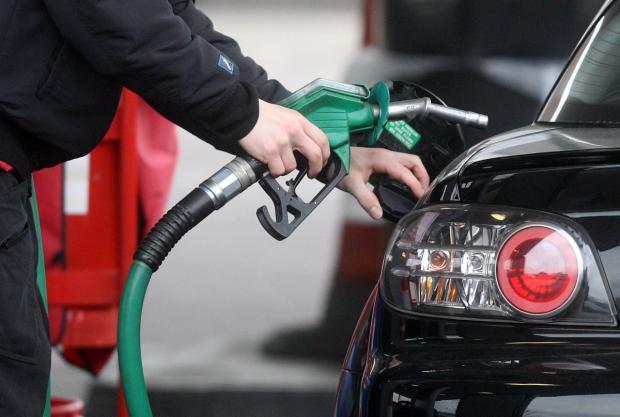 In Cumbria: Someone using a fuel pump at a petrol station (PA)